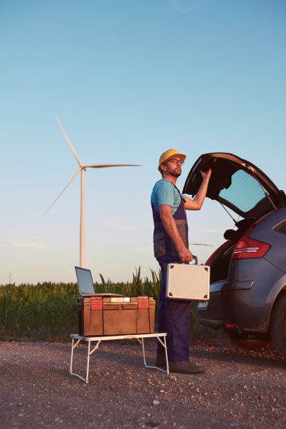 机械工程师在风车农场公园检查和维修风力涡轮机。图片下载