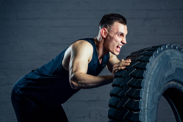 一个年轻人在健身房用轮胎做运动图片下载