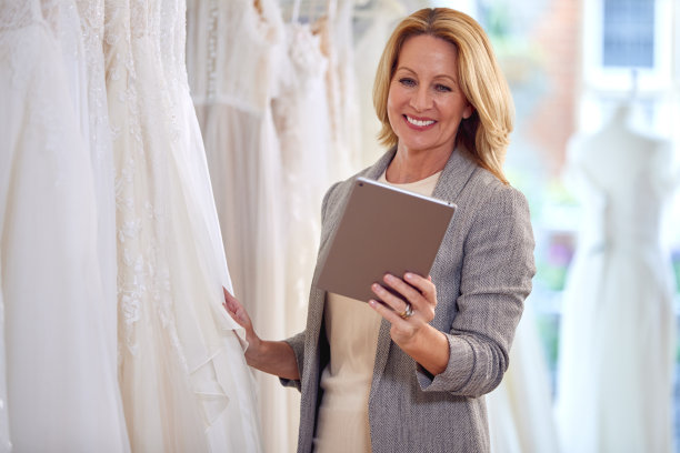 拥有数码平板电脑的新娘婚纱店女店主图片下载