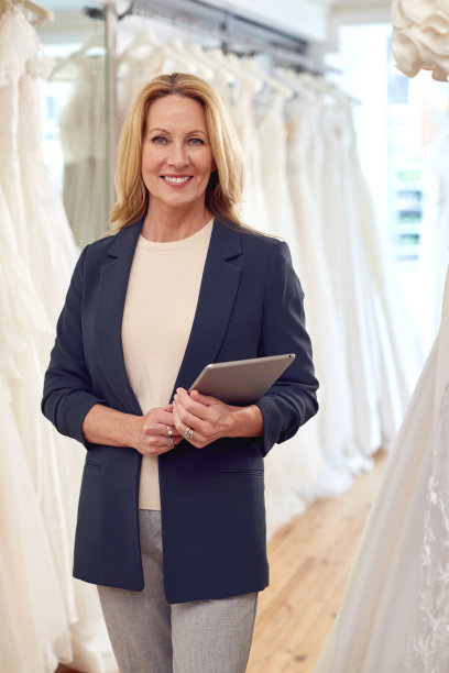 新娘婚纱店店主的肖像与数码平板电脑图片下载