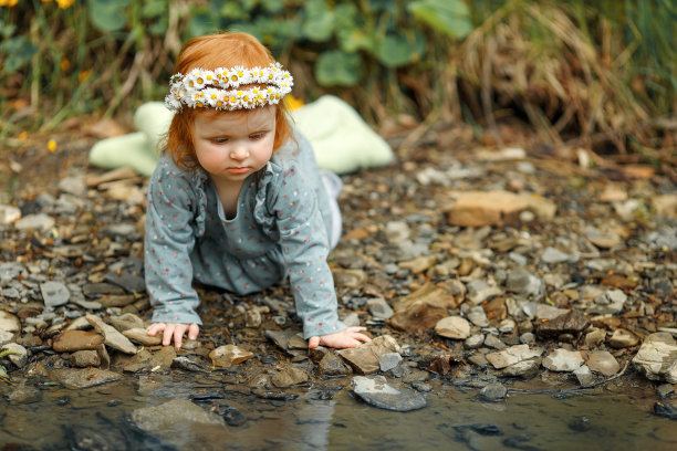 可爱的小女孩坐在小溪边图片下载