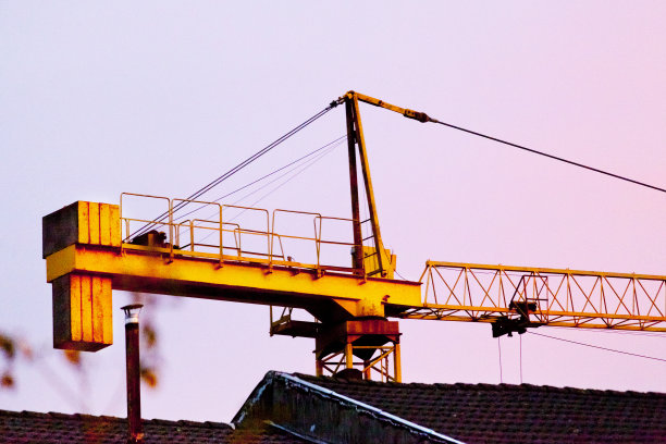 施工起重机在黄昏，夕阳的颜色背景。加利西亚,西班牙。图片下载
