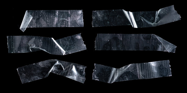 一套透明胶粘塑料胶带，孤立在黑色背景上，胶皱塑料胶带图片下载