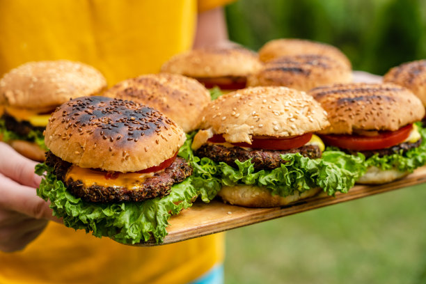 特写:用新鲜蔬菜做的自制汉堡放在木盘子里，上面放着女人图片下载