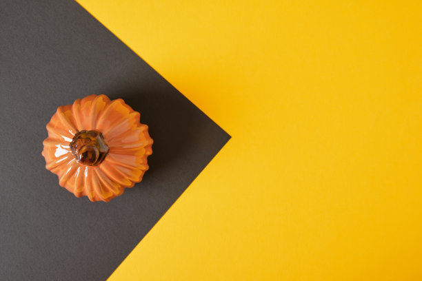 陶瓷橙色南瓜在黑色和黄色背景拷贝空间图片下载