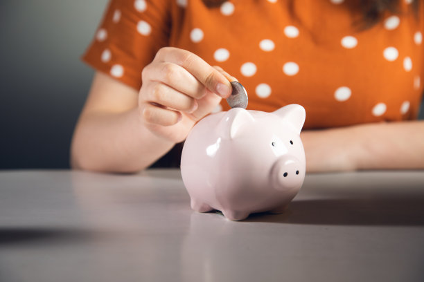 女人把硬币放进储蓄罐图片下载