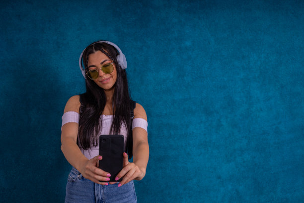 漂亮的另类年轻女子使用手机图片下载