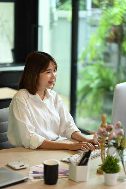 漂亮的亚洲女员工打字商务邮件，工作在明亮的现代工作场所。图片下载