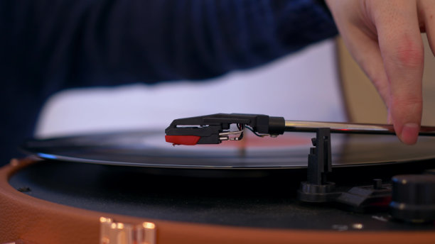 从黑胶唱片播放音乐的针的特写。他们把唱片放进播放机，它开始旋转，然后他们释放角落，播放留声机里的音乐图片下载
