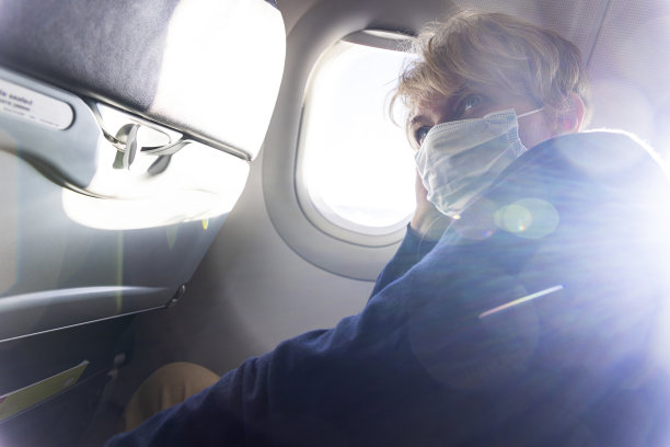 坐在飞机上的乘客。阳光会产生强烈的透镜耀斑。图片下载