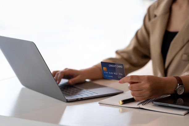 女商人手持信用卡，使用笔记本电脑。特写女性的手信用卡支付。网上购物的概念。图片下载