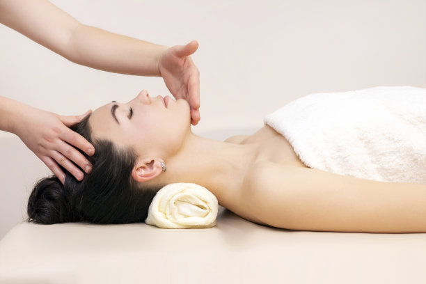 按摩和身体护理。女性头部和颈部的水疗按摩。一个女人正在为一个美丽的女孩做水疗按摩图片下载