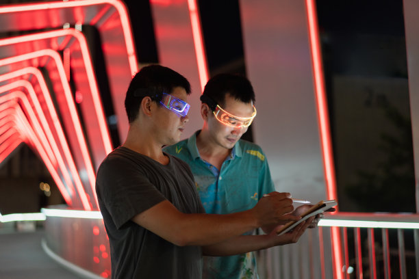 两名戴着智能眼镜的男子正在使用平板电脑图片下载