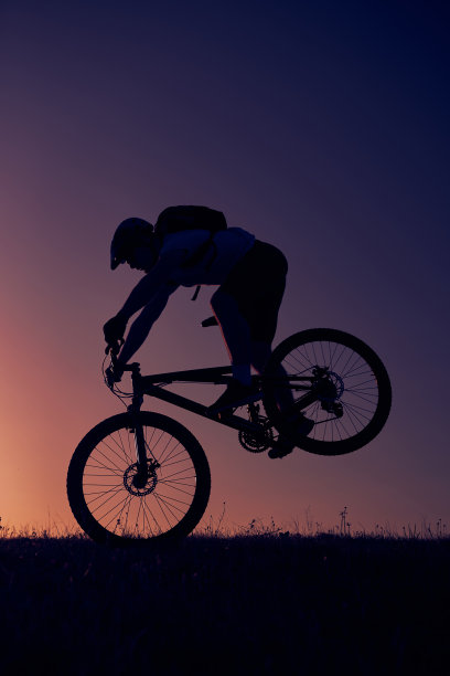 一个骑自行车的人在日落的山上图片下载