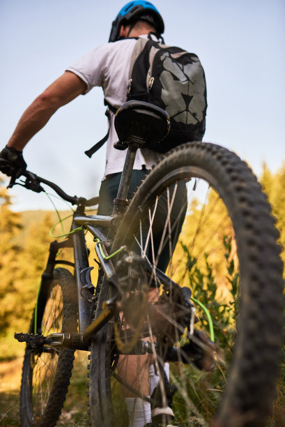 一个骑自行车的人骑在他旁边的自行车穿过森林的道路图片下载