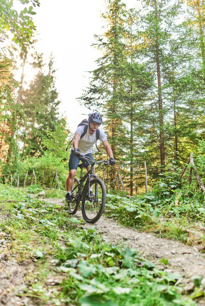 一个骑自行车的人骑在极端和危险的森林道路。有选择性的重点图片下载