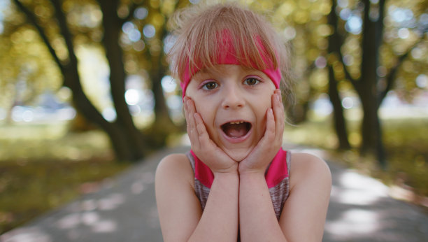 运动健身跑步女孩举起手惊讶地看着镜头震惊于突然的胜利图片下载