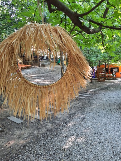 在树下的砾石屋顶花园的照片，有一面华丽的镜子图片下载