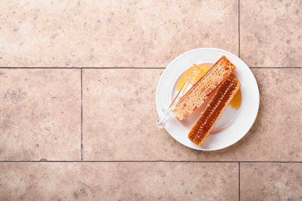 犹太新年。甜美的蜂巢与蜂蜜，苹果和石榴在浅米色旧质朴的混凝土背景表。犹太新年节日贺卡。犹太新年的节日属性。图片下载