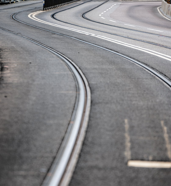 沥青路面上的电车轨道曲线。图片下载