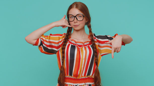 红发女孩看着镜头做着手机手势说，嘿，你给我回电话，联系电话图片下载