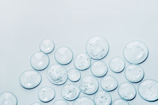 液体凝胶抽象化妆品样本滴在蓝色背景。涂抹透明保湿产品图片下载