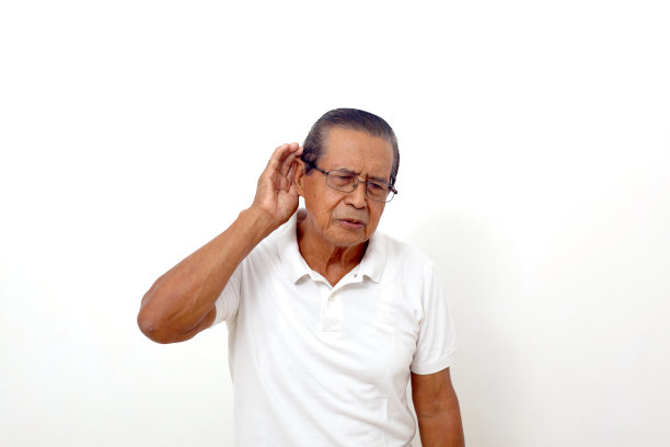 肖像的亚洲人站着，而把他的手靠近他的耳朵和听。孤立在白色图片下载