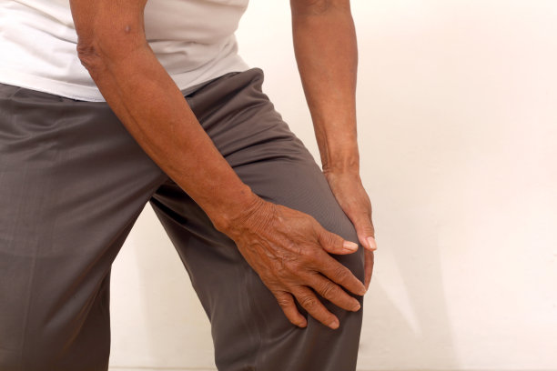 老人的手握住膝盖的特写照片。膝盖疼痛。孤立在白色的。图片下载