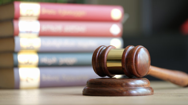 法官用小木槌或铁锤敲打成堆的法律书籍图片下载
