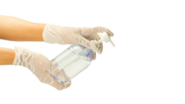女性戴上手套，在白色背景上涂上酒精凝胶。图片下载
