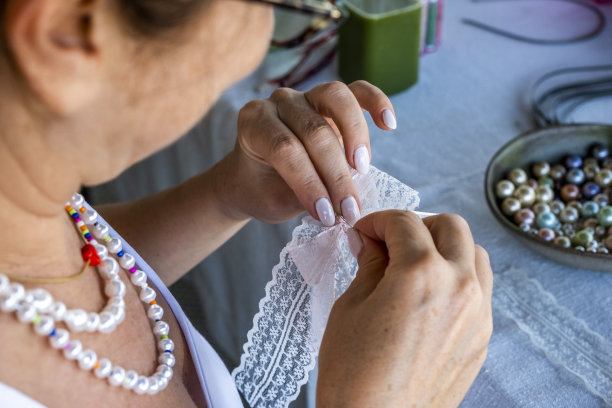 女人正在缝制蕾丝手链，俯视图图片下载