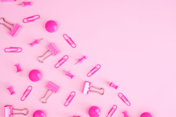 粉红色空白对角分割。散落在半张回形针、图钉、活页夹上图片下载