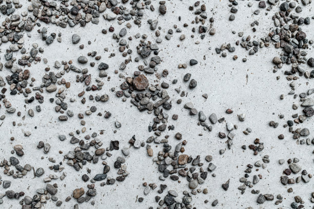 浅石表面散落的灰色小石头特写。抽象背景纹理图片下载