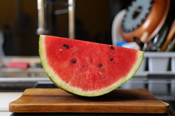 一块西瓜放在木砧板上图片下载