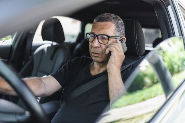 70多岁的老人一边开车一边用手机图片下载