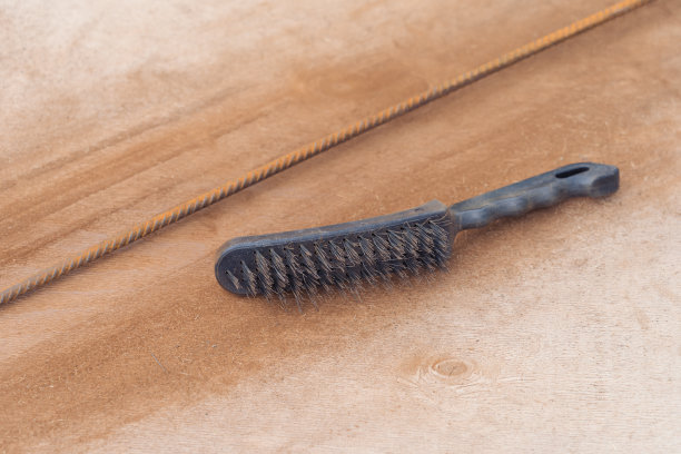 金属除锈刷放在生锈的金属棒旁边图片下载