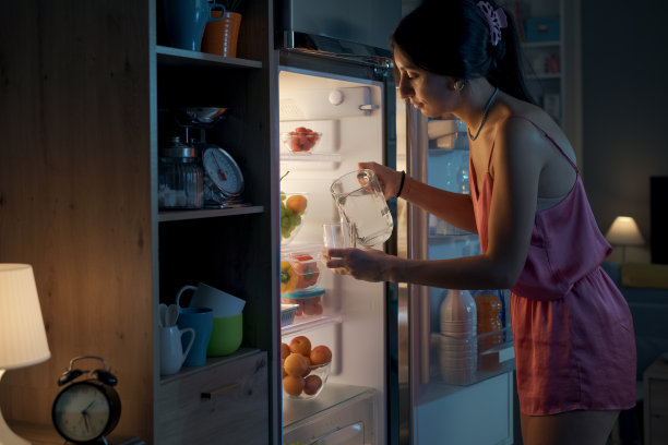 口渴的女人晚上看冰箱图片下载