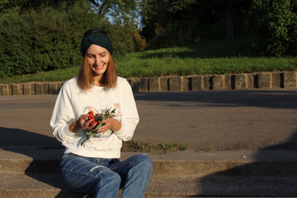 头巾钩织在大街上的女孩。产品挂牌出售。城市的风格。时尚。图片下载