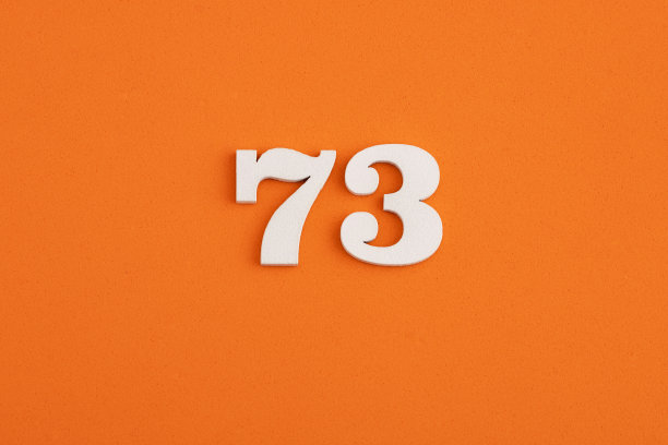 白色木制数字73 eva橡胶橙色背景图片下载