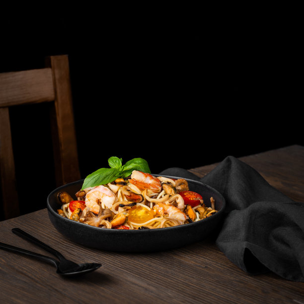 意大利海鲜。意大利面配虾、奶油酱和罗勒。黑色木桌的俯视图。图片下载