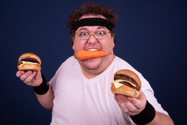 运动、健身和健康的生活方式。有趣的胖子喜欢运动，还会吃汉堡。图片下载