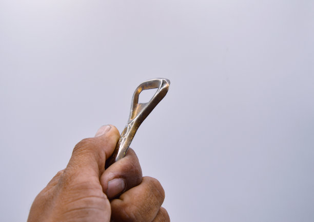 旧的金色开瓶器手柄白色背景图片下载