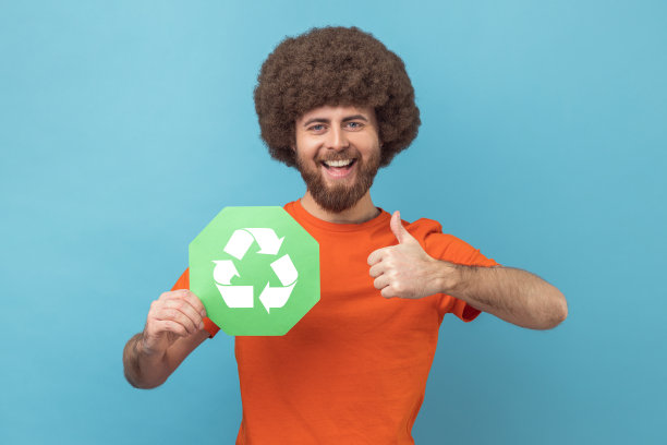 手持垃圾回收标志的男子竖起大拇指，为生态担忧。图片下载