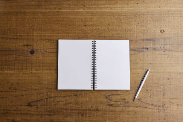 黑色的纸笔记本放在桌子上图片下载