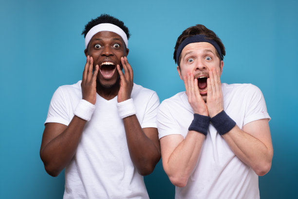 两个年轻人疯狂地把手举到脸上。图片下载