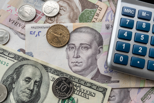 欧元和格里夫纳分散在桌子周围，有一个计算器来确定汇率。图片下载