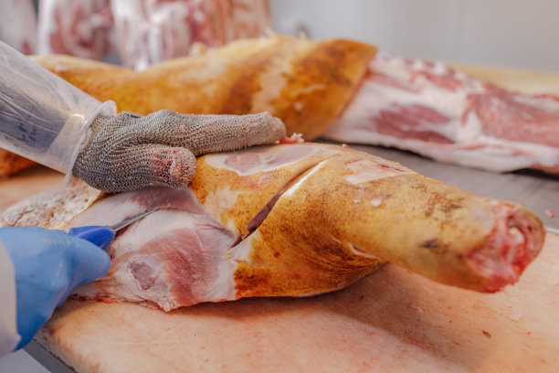 食品工业肉类加工的特写，一名工人切生猪肉，肉制品的概念图片下载