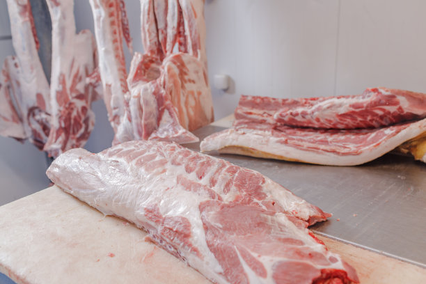 食品工业肉类加工的特写，一名工人切生猪肉，肉制品的概念图片下载