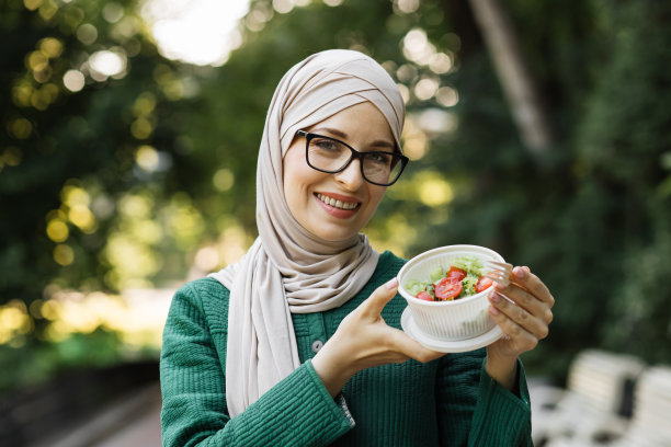 开朗的穆斯林妇女在户外吃健康午餐。图片下载