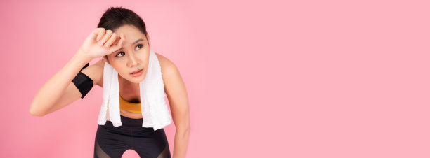 疲惫的健身女孩筋疲力尽后，运动和擦汗运动的女人弯下腰，双手放在膝盖上累漂亮年轻的亚洲女人在跑步后休息，孤立的粉红色图片下载